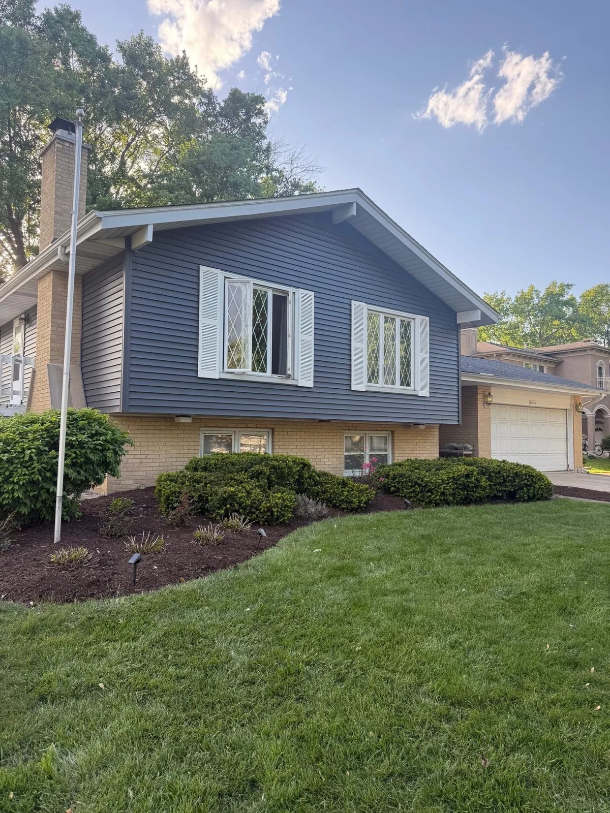 New blue lap siding with white trim and shutters in Darien, Illinois
