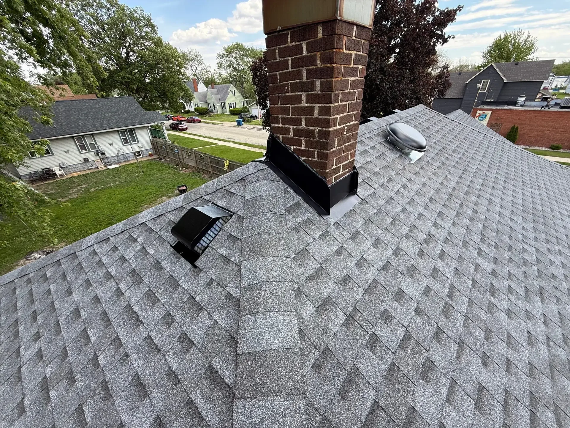 Chimney flashing and roof vent details on a shingle roof in Kankakee, Illinois